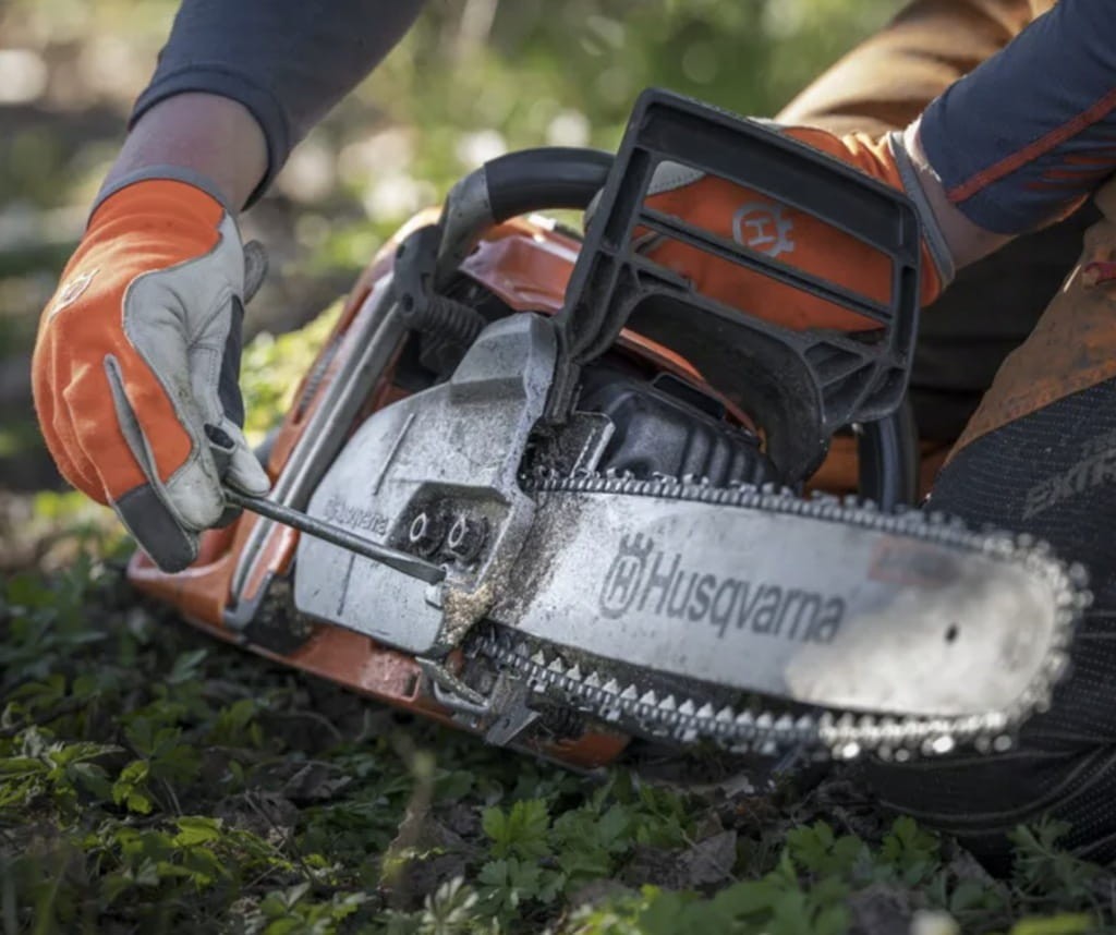 Zbliżenie na niegubiące się nakrętki prowadnicy w Husqvarna 562 XP