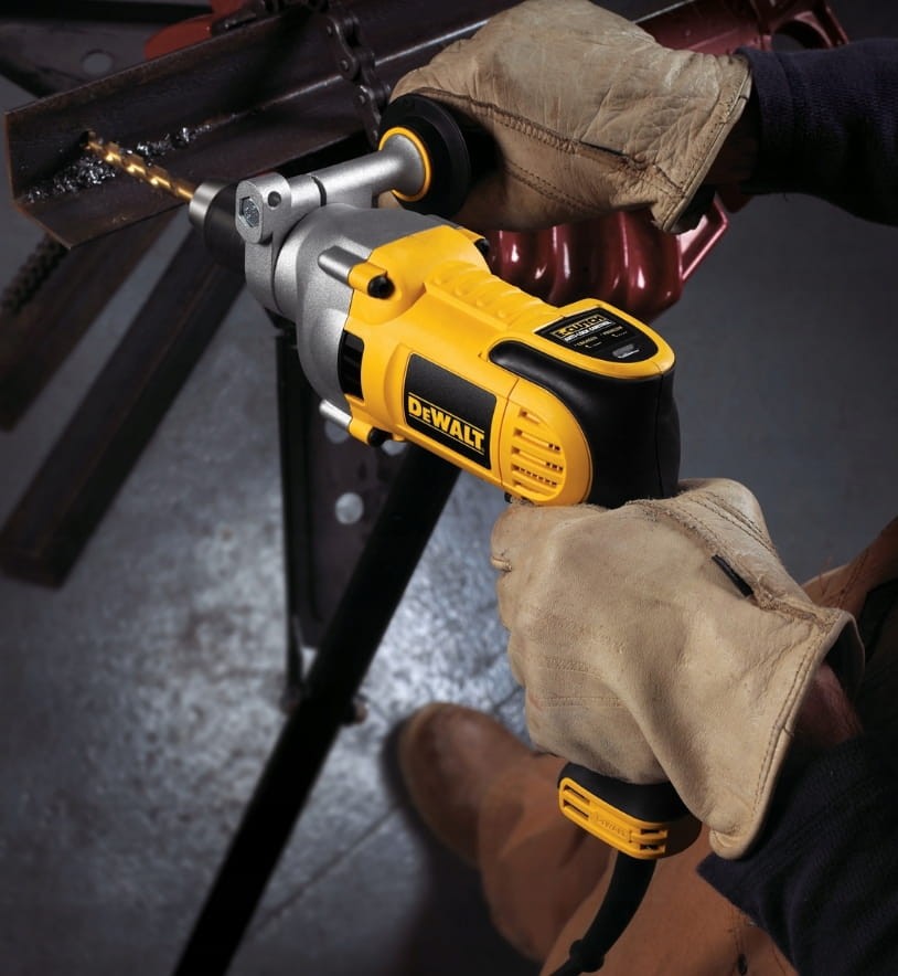Wiercenie w rurze stalowej wiertarką DeWalt DWD524KS w rękawicach ochronnych
