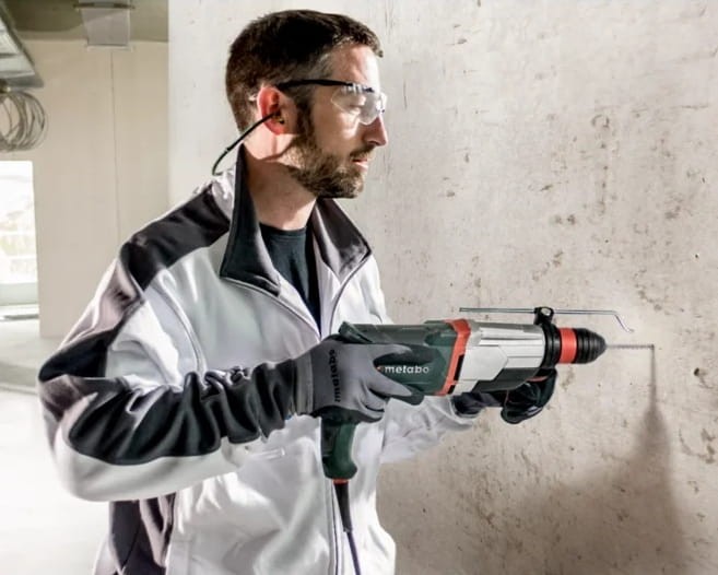 Monter instalacji używający Metabo KHE 2860 w surowym wnętrzu
