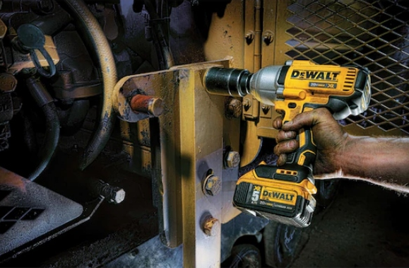 Serwis maszyn ciężkich - mechanik używający klucza DeWalt DCF899 przy łożysku