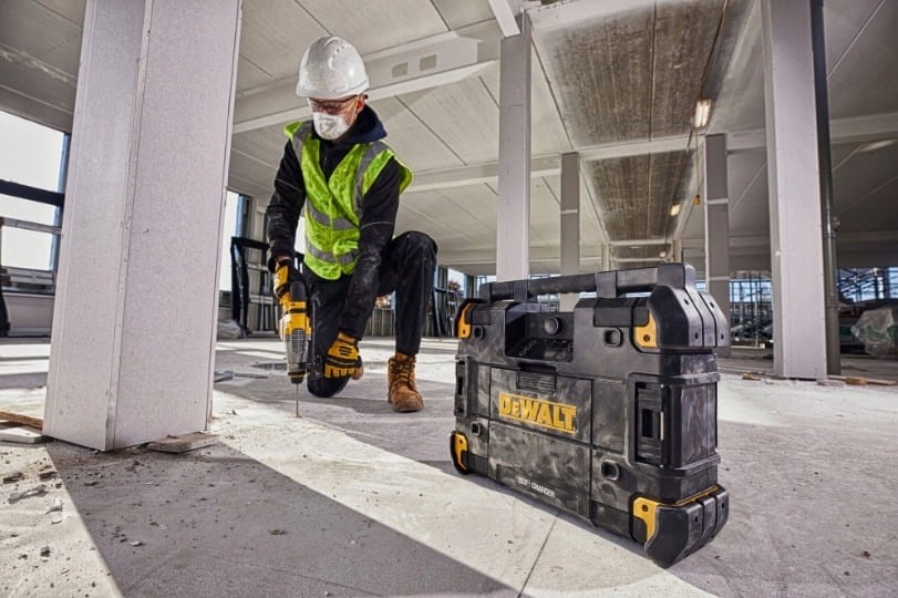 Pracownik budowlany używający radia DeWalt TSTAK na posadzce betonowej