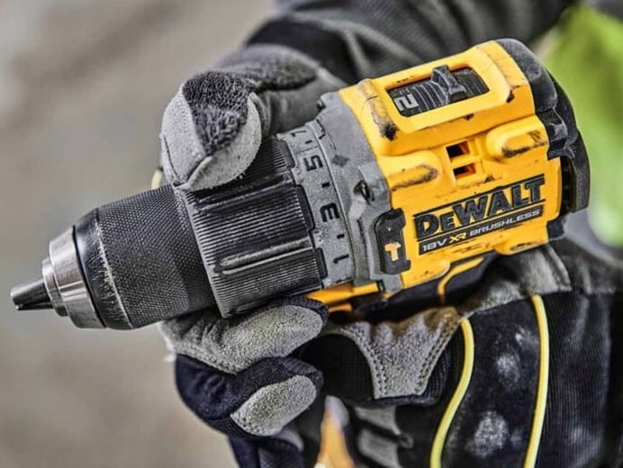Operator w rękawicach używający wkrętarki DeWalt DCD805 do prac montażowych