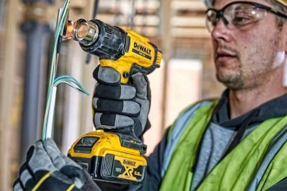 Elektryk obkurczający izolację przewodów opalarką DeWalt w puszce